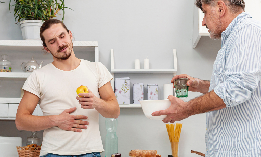 Man with stomach discomfort discussing diet choices that support better gut health and digestion.
