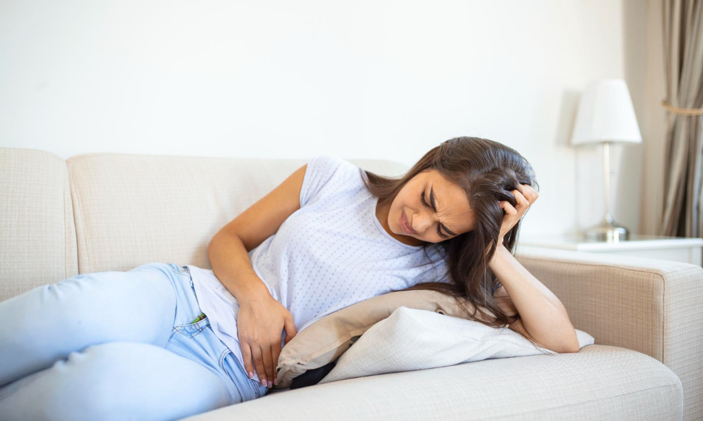 Woman experiencing constipation and stomach discomfort, highlighting the need for natural gut health solutions like natto