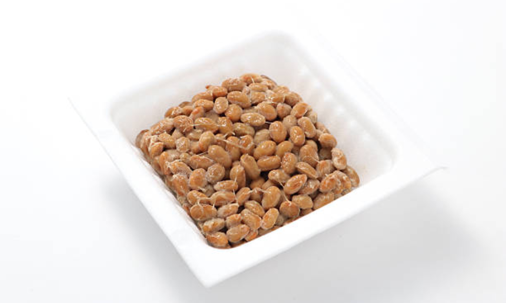 Traditional natto fermented soybeans in a white container, a Japanese superfood rich in probiotics, vitamin K2, and nattokinase.