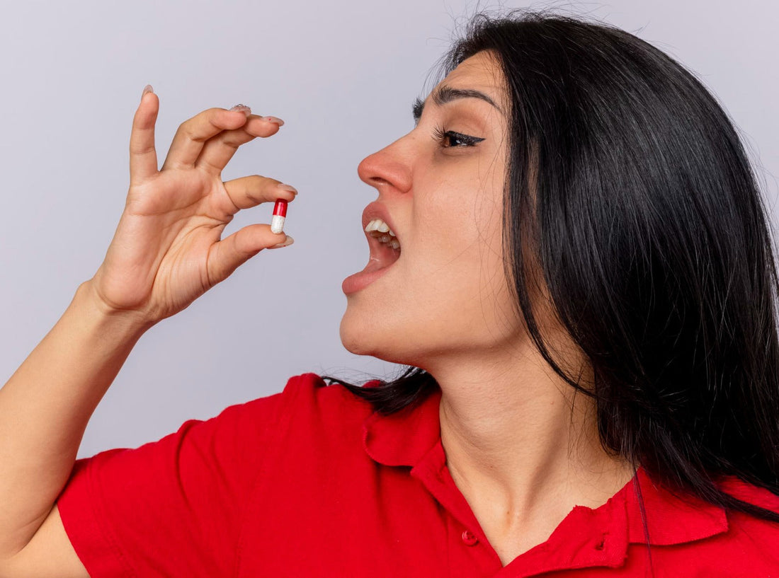 Woman taking a nattokinase capsule as part of a daily wellness routine, highlighting heart health, cardiovascular health, and healthy ageing.