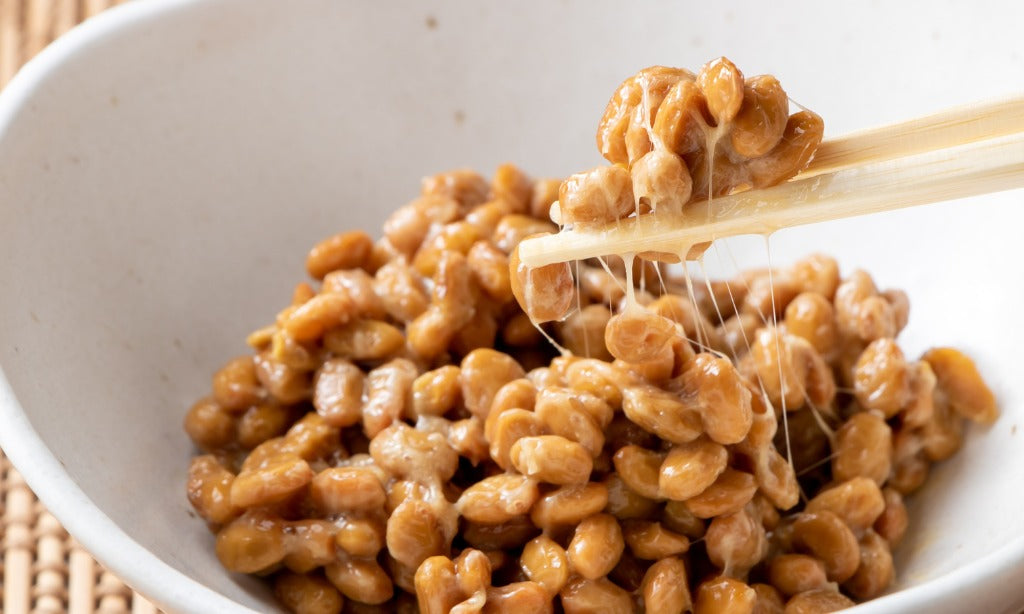 Sticky natto fermented soybeans being picked up with chopsticks showing probiotic-rich food for gut health