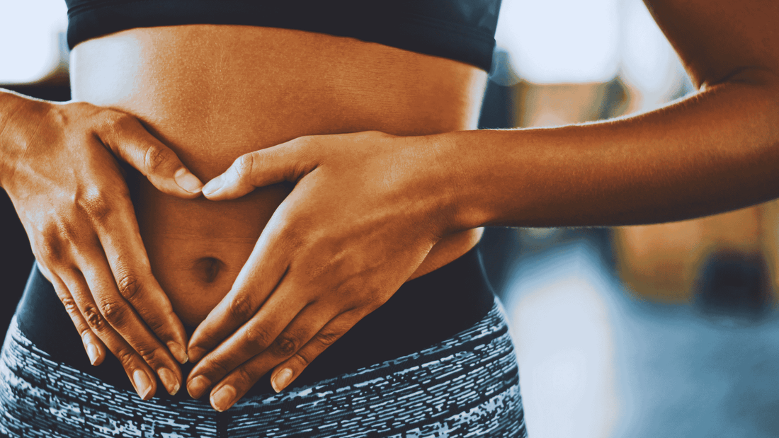 Person gently holding abdomen symbolising gut health and digestive wellness supported by fermented nutrition
