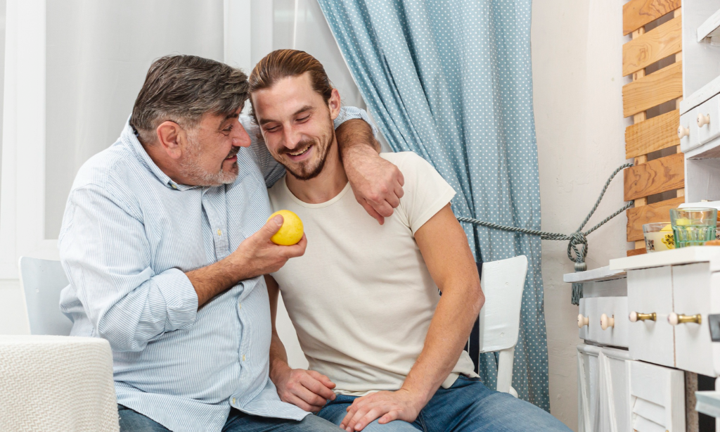 Father and son smiling together at home, highlighting family, health, and healthy ageing.
