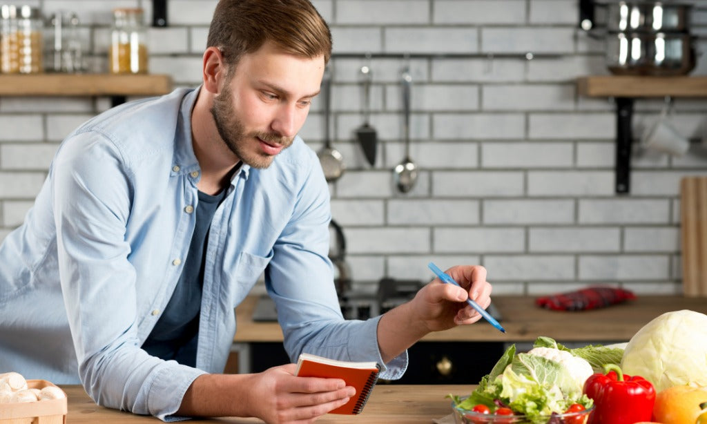 Person holding their stomach with visible discomfort, representing chronic bloating and digestive discomfort despite a healthy diet.